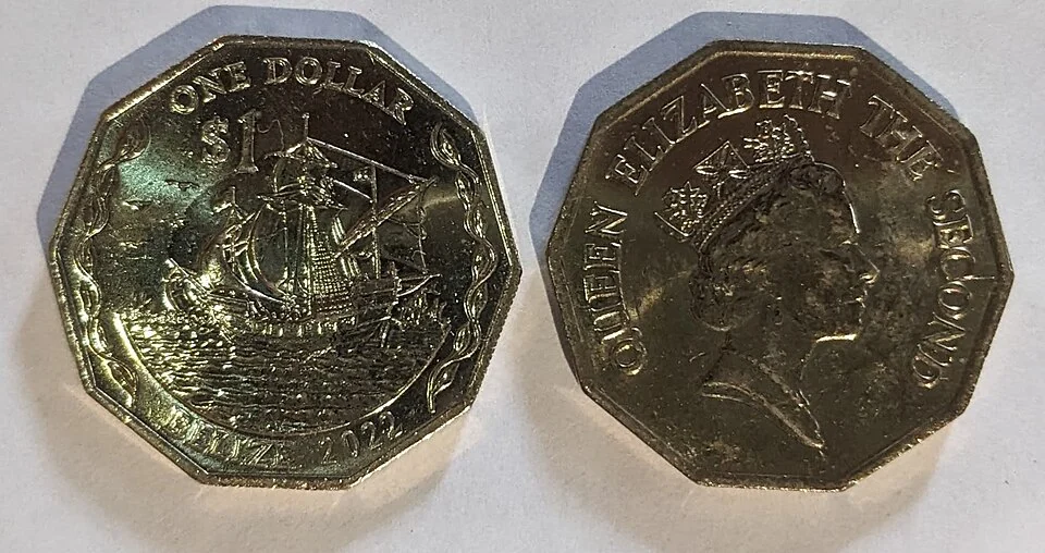 Both faces of a Belize one-dollar coin, the reverse showing a sailing ship with the words ONE DOLLAR and BELIZE 2022, the obverse a portrait of Queen Elizabeth the Second.